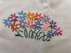 a white shirt with colorful flowers embroidered on it