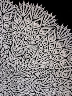 an intricate white doily on a black background