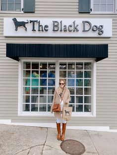 a woman standing in front of the black dog store with her hand on her hip