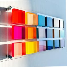 a wall mounted shelf filled with lots of different colored boxes