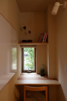 a desk with a chair and bookshelf in front of a window that looks out onto the woods