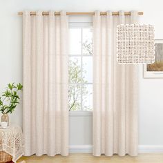 a living room with white curtains and a plant in front of the window on top of a wooden floor