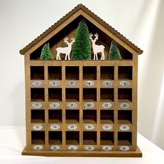 a wooden calendar with deer and trees on it's sides is shown in front of a white background