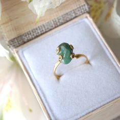 Dark green and gold create an emerald ring that sings with elegance and stands for bravery. The adjustable ring easily fits various ring sizes. The 14k gold filled metal setting creates a long-lasting and hypoallergenic ring. Each handmade pair uses a three step adhering process to guarantee durability and quality, Hypoallergenic material guarantees no reaction when you wear them. As no raw stone is the same, each emerald ring has a slightly different shape and size guaranteeing uniqueness and i Heirloom Style Green Emerald Open Ring, Adjustable Elegant Jade Rings, Elegant Gold Jade Ring, Heirloom Style Green Emerald Ring As Gift, Heirloom Green Emerald Ring As Gift, Adjustable Gold Emerald Ring As Gift, Adjustable Green Jade Rings, Adjustable Oval Emerald Ring For Gift, Adjustable Gold Emerald Ring For Anniversary