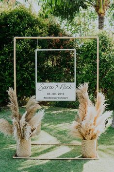 two vases with pamodia in front of a sign that says sara and nick