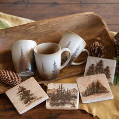 coffee cups and coasters on a tray with pine cones