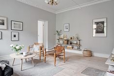 a living room filled with furniture and pictures on the wall