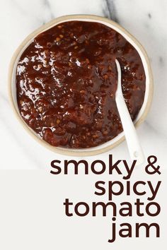 a bowl of smoky and spicy tomato jam with a spoon in it on a marble surface