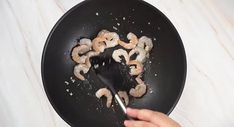 someone is frying shrimp in a skillet with a spatula on the side