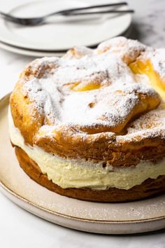 a cake sitting on top of a plate covered in powdered sugar and icing