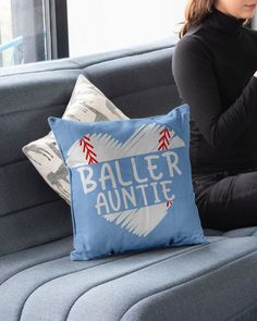 a woman sitting on a couch with a pillow that says baller annte in red and blue