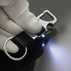 a close up of a person wearing gloves and holding a light on top of a table