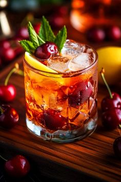 an old fashioned cocktail with cherries and mint garnish