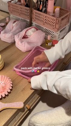 a person is holding a pink tray on a desk with other items in the background