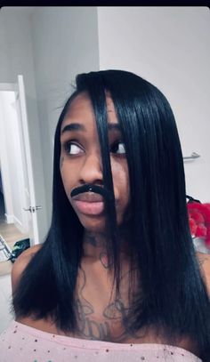 a woman with long black hair and a moustache on her face