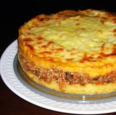 a cheesy dish sitting on top of a white plate