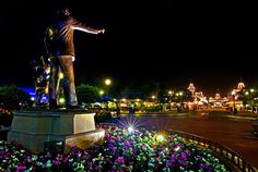 there is a statue in the middle of a flower bed