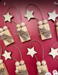 wooden stars are tied with twine to hang from strings on a red wall, which is decorated with wood balls and string