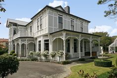 a large white house sitting on top of a lush green field