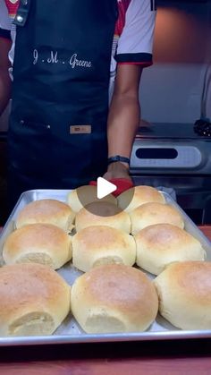 a man in an apron is making rolls on a pan