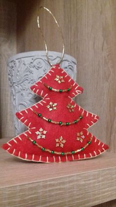 a red christmas tree ornament sitting on top of a shelf