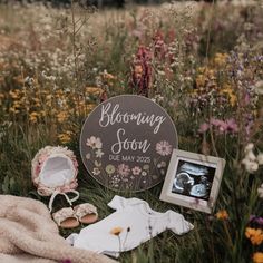 a baby's birth announcement is shown in the middle of a field with flowers