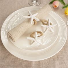 the plate is decorated with starfish napkins and burlap wrapped in burlap