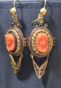 "Holding you spellbound, this captivating Victorian coral cameo pin and earring set are exceptional. The set dates from the late 1880's. It is set in 14k yellow gold. The elaborately detailed raised carving of a Victorian young lady is a masterful work of art. The gold frame is intricate and extravagant filled with braided gold and artistic open work. The pin can easily be converted in to a pendant. The pin measures 2 ¾\" long and 2\" wide. The matching earrings are equally dramatic and stunning Victorian Cameo Yellow Gold Earrings, Victorian Cameo Earrings For Formal Occasions, Formal Cameo Yellow Gold Earrings, Formal Yellow Gold Cameo Earrings, Victorian Pierced Earrings For Evening, Cameo Drop Earrings For Formal Occasions, Antique Evening Earrings For Pierced Ears, Victorian Oval Pierced Earrings, Victorian Earrings For Evening Occasions