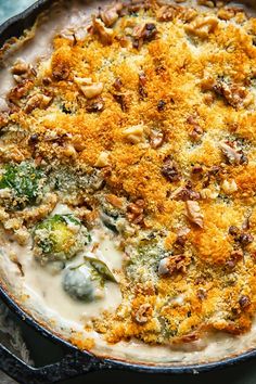 a casserole dish with broccoli, cheese and other toppings on it