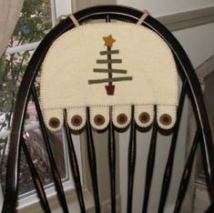 a rocking chair with a christmas tree on it's back and buttons at the bottom