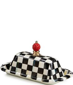 a black and white checkered tray with a red knob on it's top