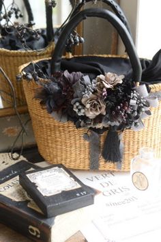 a basket with flowers is sitting on a table next to some books and other items