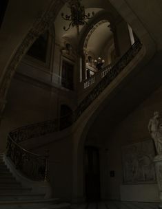 an ornate staircase and chandelier in a large room with marble statues on either side