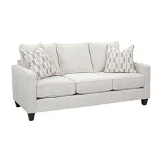 a white couch with two pillows on it's back and one pillow in the middle