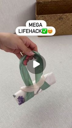 someone is holding a green and white ribbon in front of a box that says mega lifehack