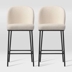 two white upholstered stools with black legs, one on the left and one on the right