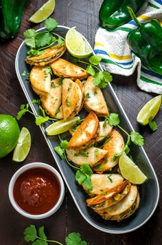 mexican food is served on a platter with salsa and limes