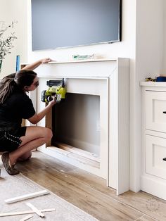 a woman sitting on the floor in front of a flat screen tv with construction tape around it