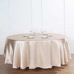 a round table with two glasses on it and a white wall in the back ground