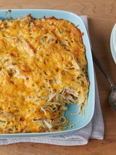 a casserole dish with noodles and meat in it on a blue plate next to a fork