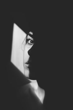 black and white photograph of a woman's face in the dark