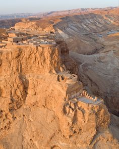 an aerial view of the desert with some buildings on it and mountains in the background