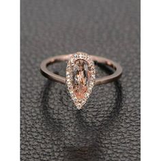 an engagement ring with a pear shaped peach colored diamond