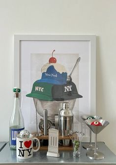 an ice cream sundae is displayed in front of a framed photograph and two martini glasses