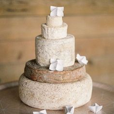 a three tiered cake sitting on top of a metal platter covered in white paper