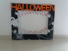 a halloween photo frame with ghostes and bats on the inside, in front of a white wall