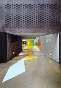 an empty parking garage with painted walls and white arrows on the floor in front of it