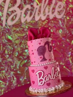 a pink cake decorated with hearts and the word barbie on it's bottom tier