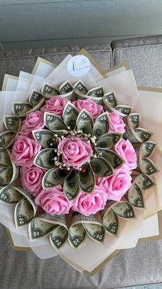 a bouquet of flowers made out of dollar bills on top of a bed of money