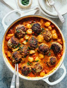 meatballs and tomato sauce in a pot with spoons